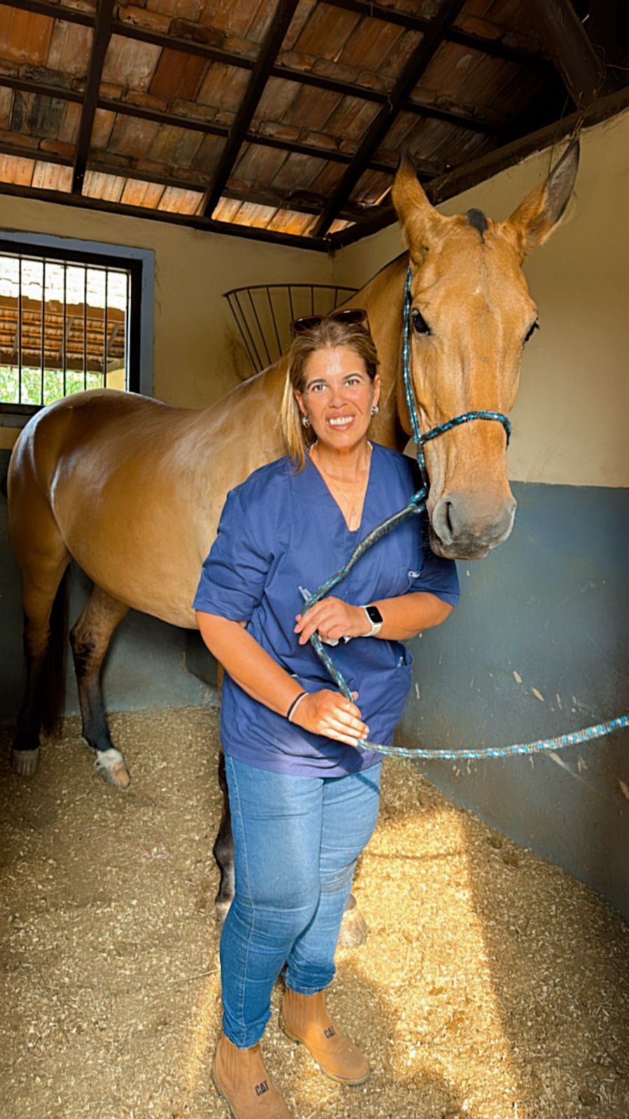 Dra. Christiana conduzindo um cavalo baio na baia